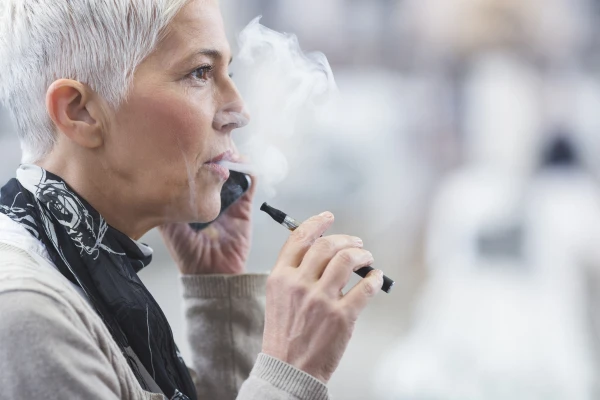 Une dame qui fume la cigarette electronique